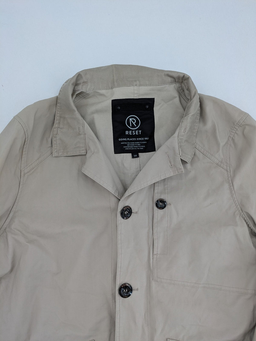 ReSET beige coat with contrasting dark blue lining and classic design details.