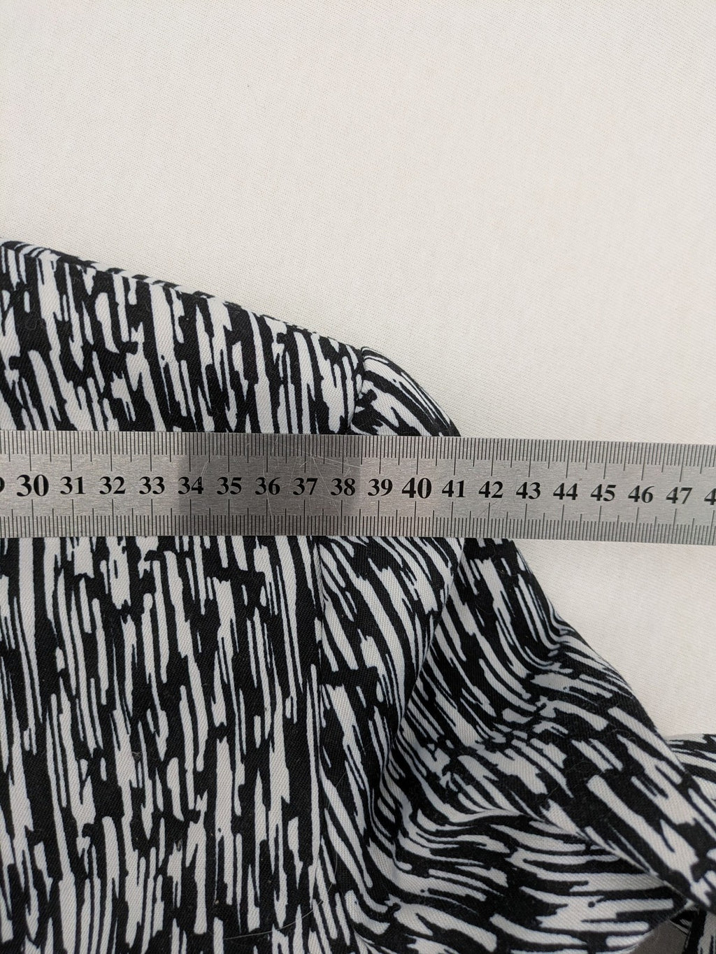 H&M Divided black and white patterned blazer with open front and two front pockets.