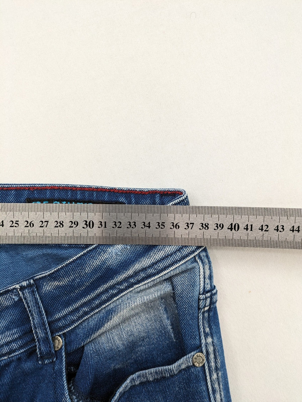 Diesel blue straight jeans with distressed details and ripped accents, made of cotton.