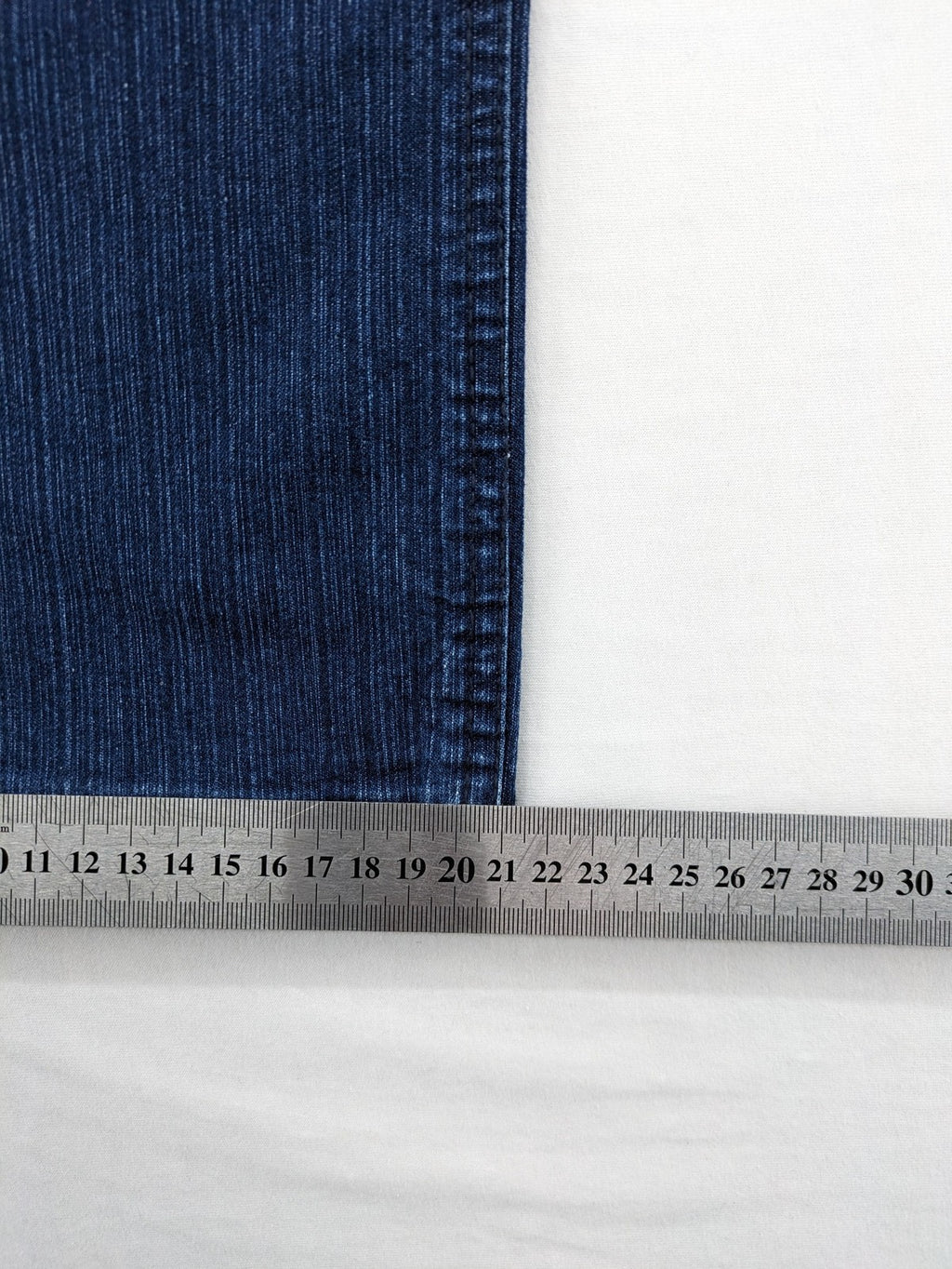 Outfit blue straight jeans with elastic waistband and embroidered crown-wing emblem on pockets.