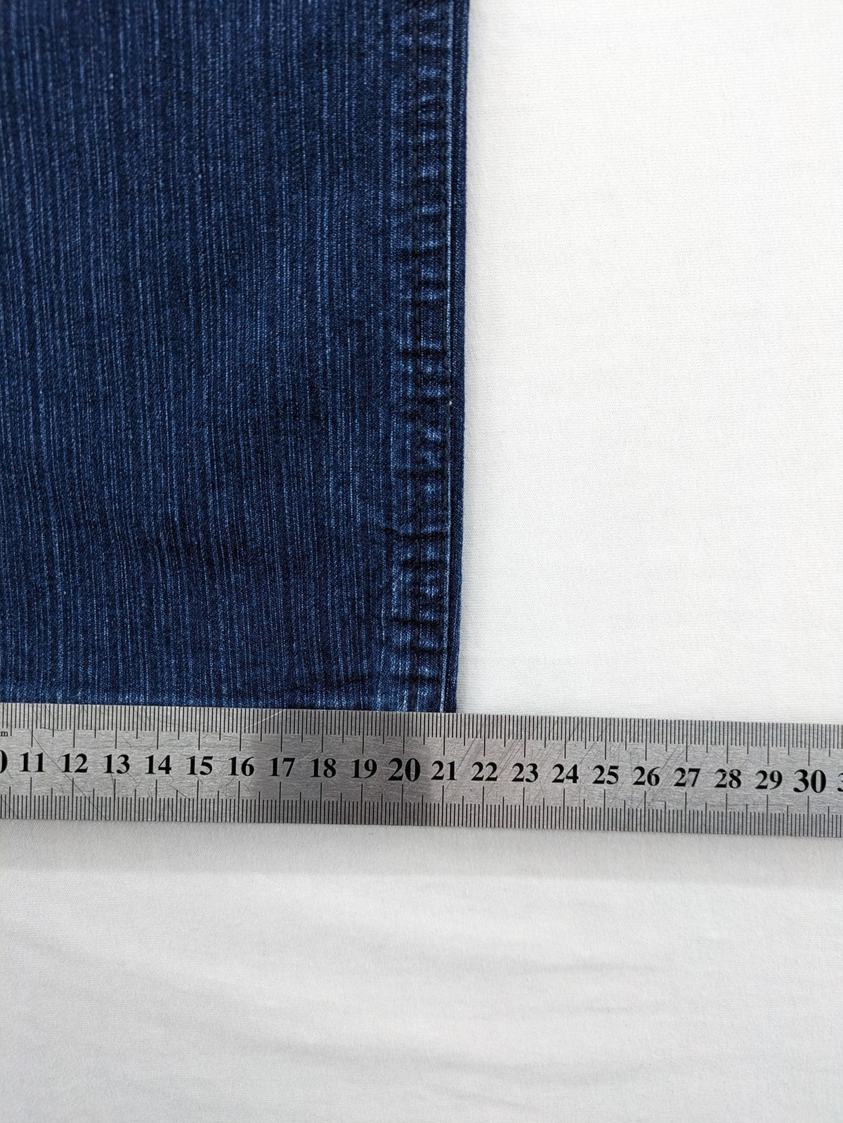 Outfit blue straight jeans with elastic waistband and embroidered crown-wing emblem on pockets.