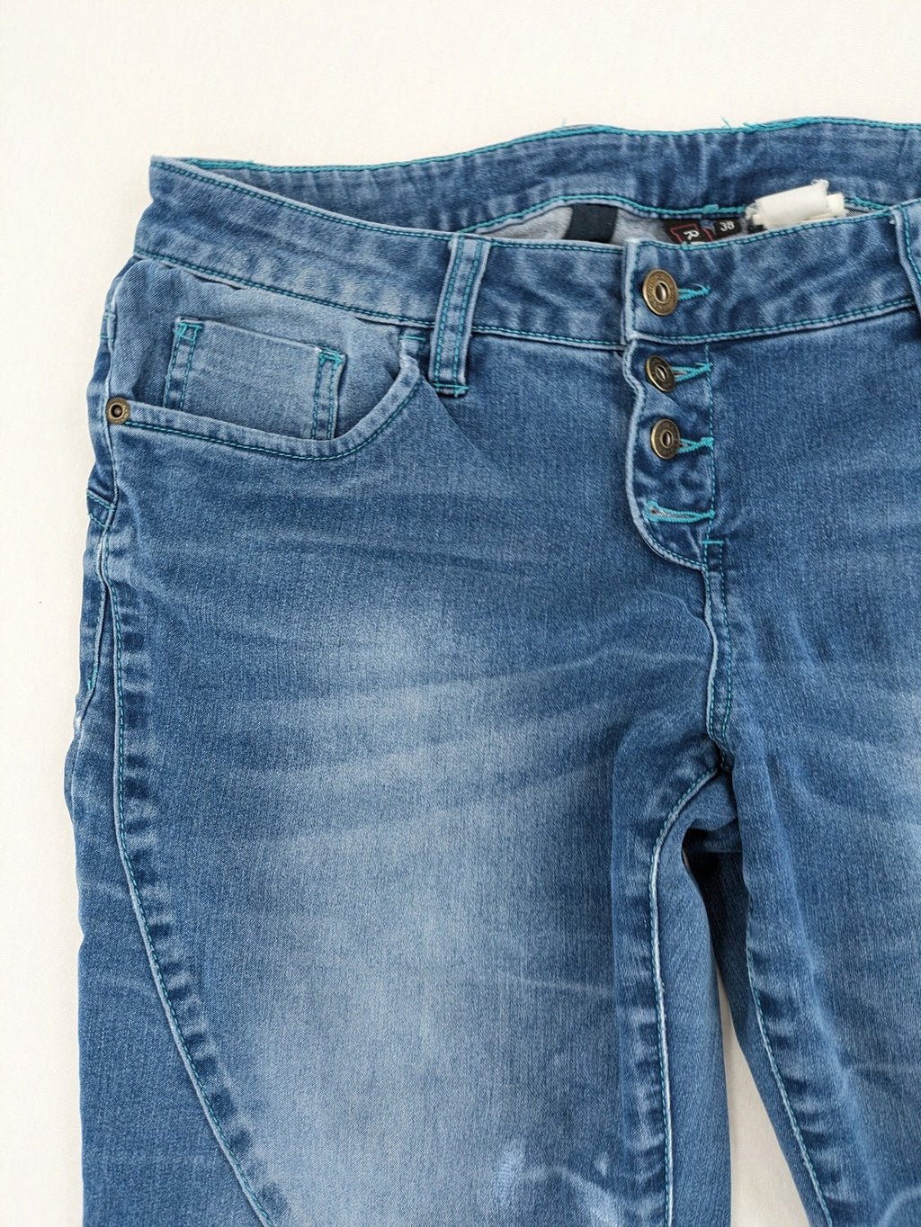 Rainbow blue straight jeans jogger style with button fly and contrasting turquoise stitching.