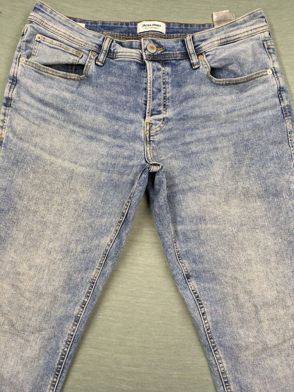 Jack & Jones blue slim fit jeans with button fly and light wash denim texture.