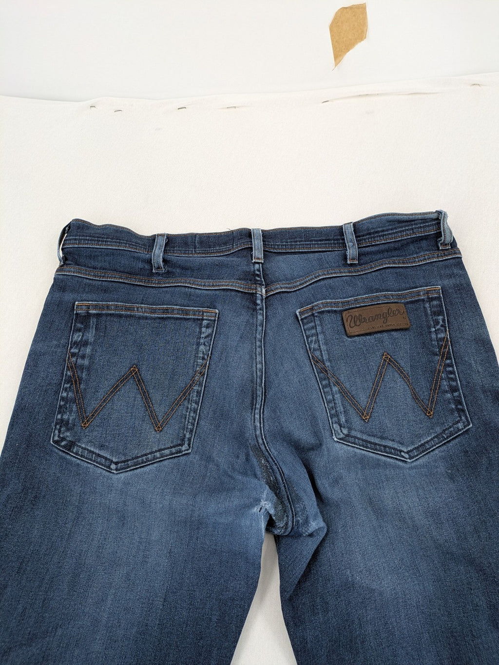 Wrangler straight jeans blue with iconic "W" stitching on back pockets.
