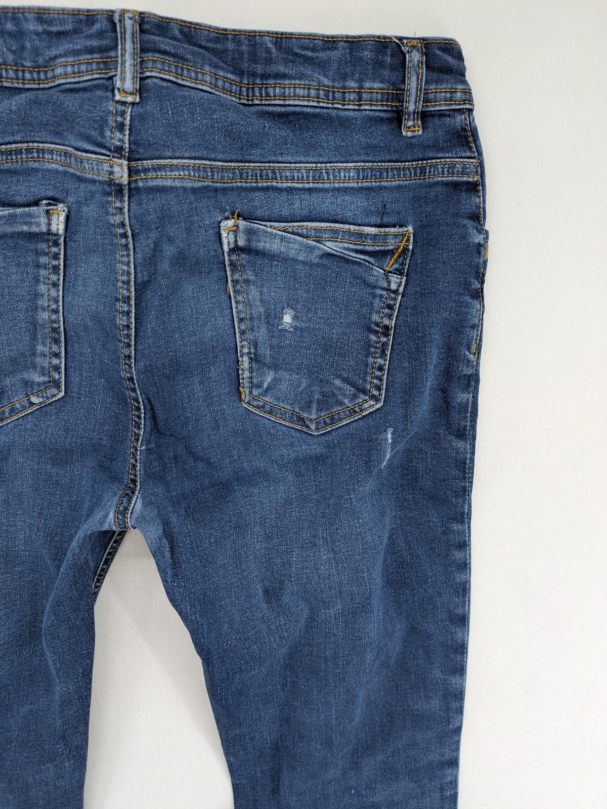 Denim & Co. blue skinny jeans with distressed ripped details and adjustable waistband.