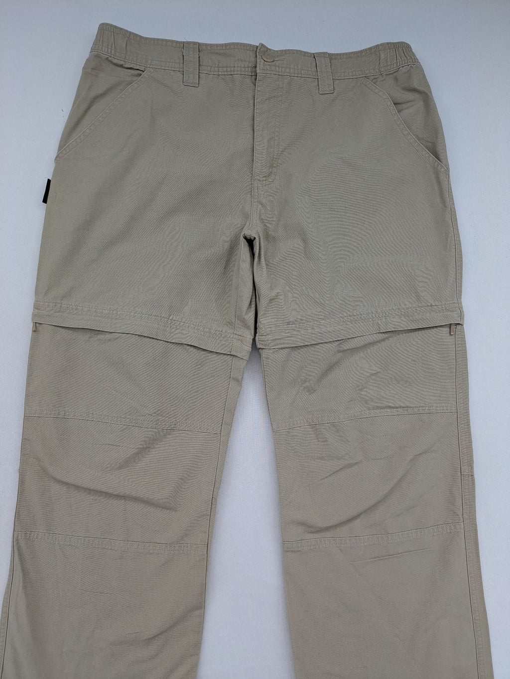 Quechua khaki convertible hiking pants with zip-off legs and durable cotton fabric.
