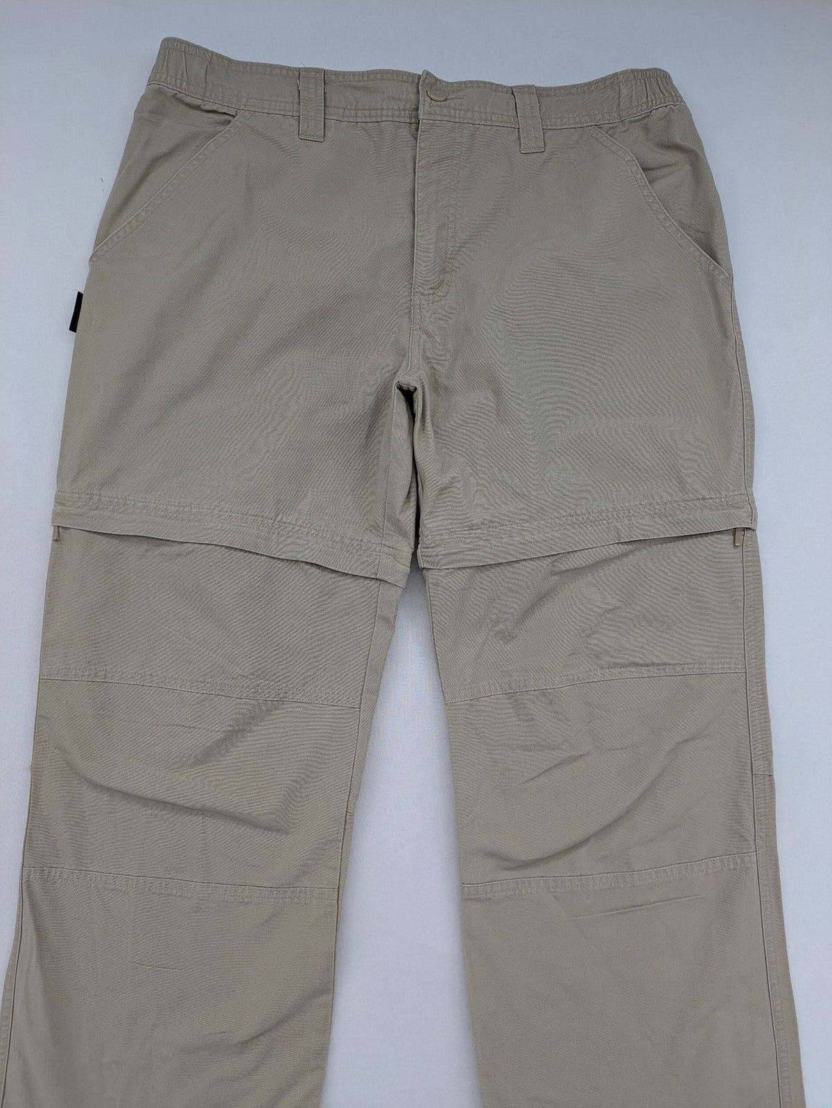 Quechua khaki convertible hiking pants with zip-off legs and durable cotton fabric.