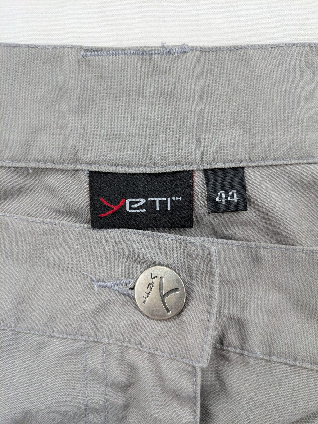 YETI grey cargo pants with multiple zippered pockets and durable material.