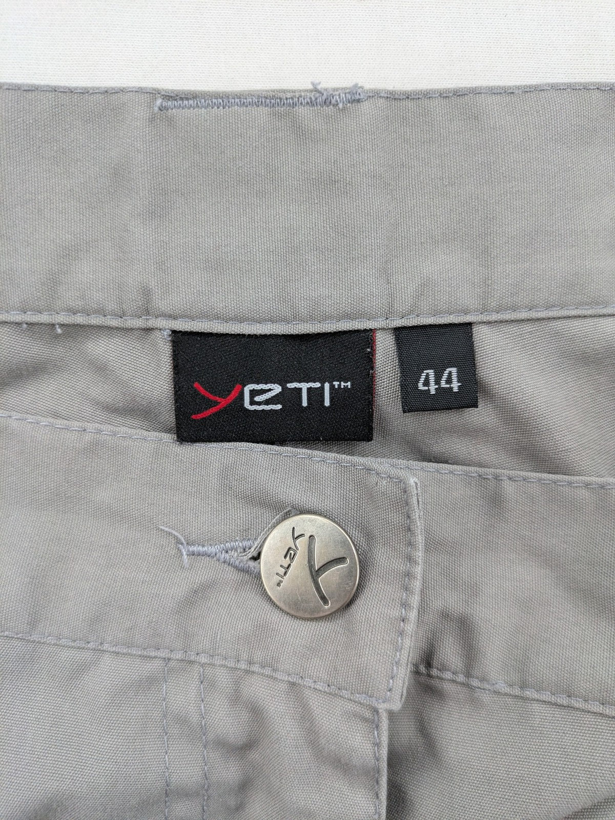 YETI grey cargo pants with multiple zippered pockets and durable material.