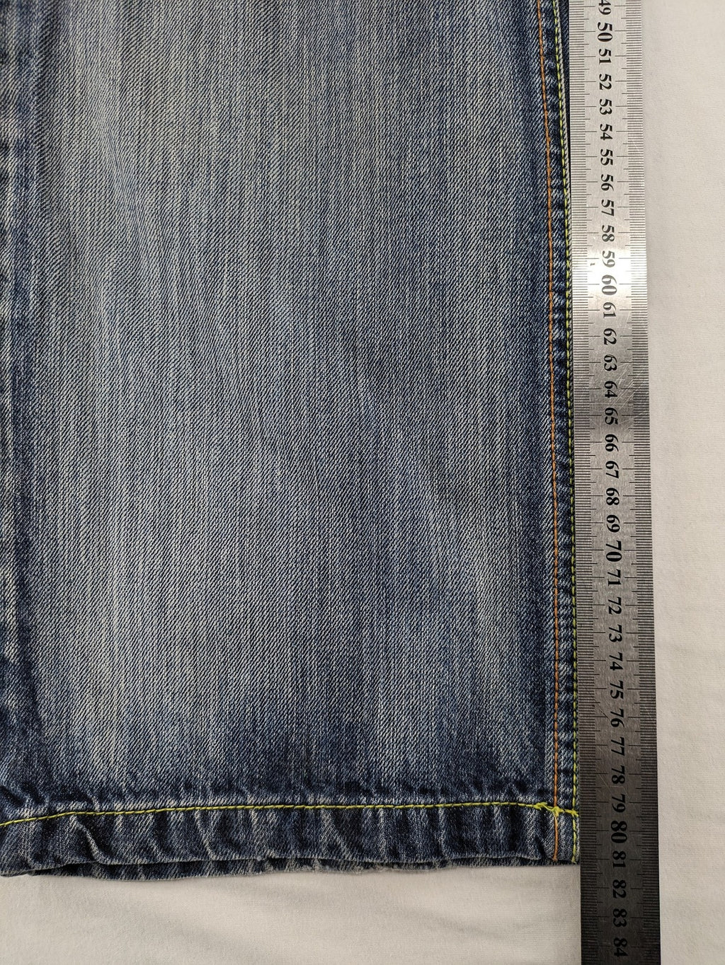 Identic orange straight jeans with paneled design and contrasting yellow stitching.