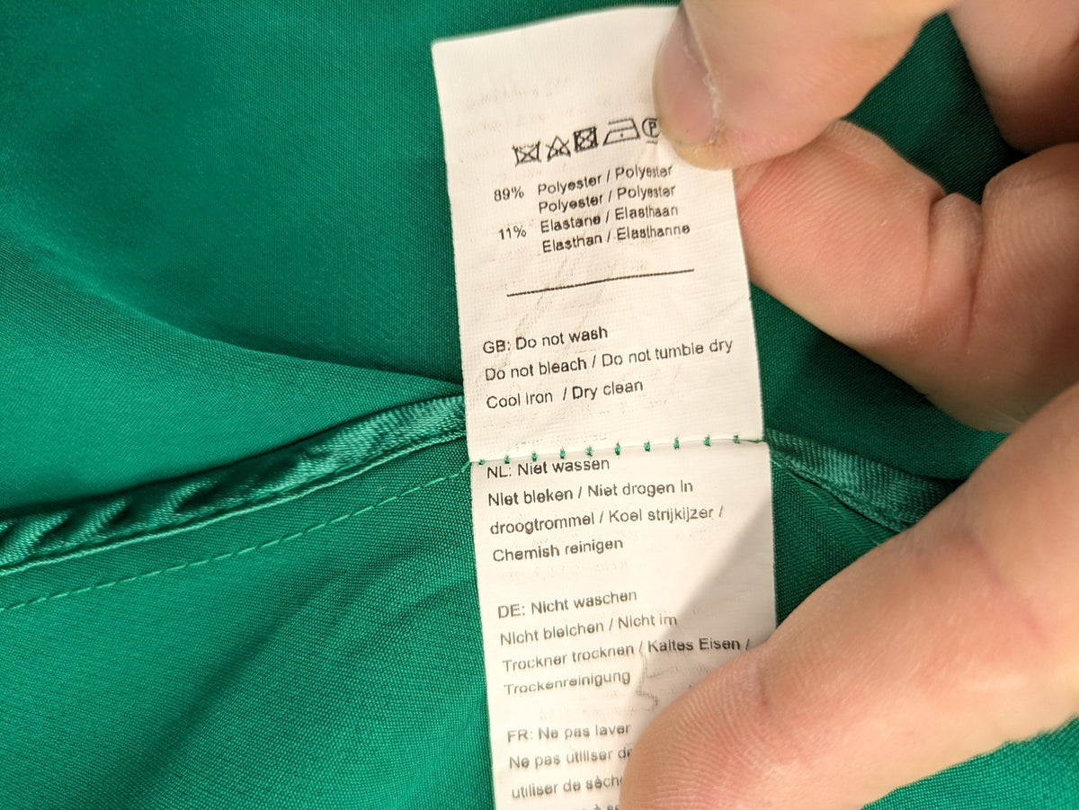 Promiss green blazer jacket single-button design with notch lapels and decorative pockets.