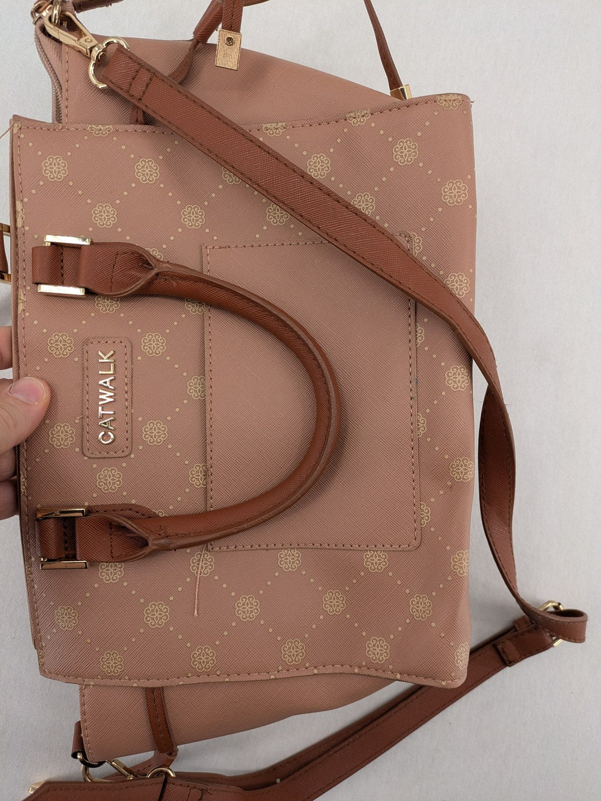 Catwalk gold handbag with pink and brown monogram pattern, adjustable shoulder strap.