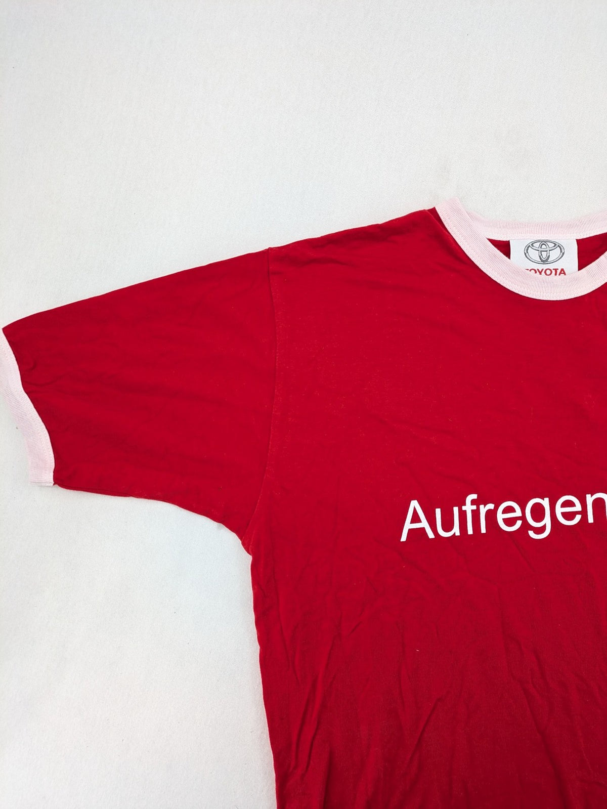 ck red Ringer T-shirt with white collar, "Aufregend.gut" slogan, 100% cotton.