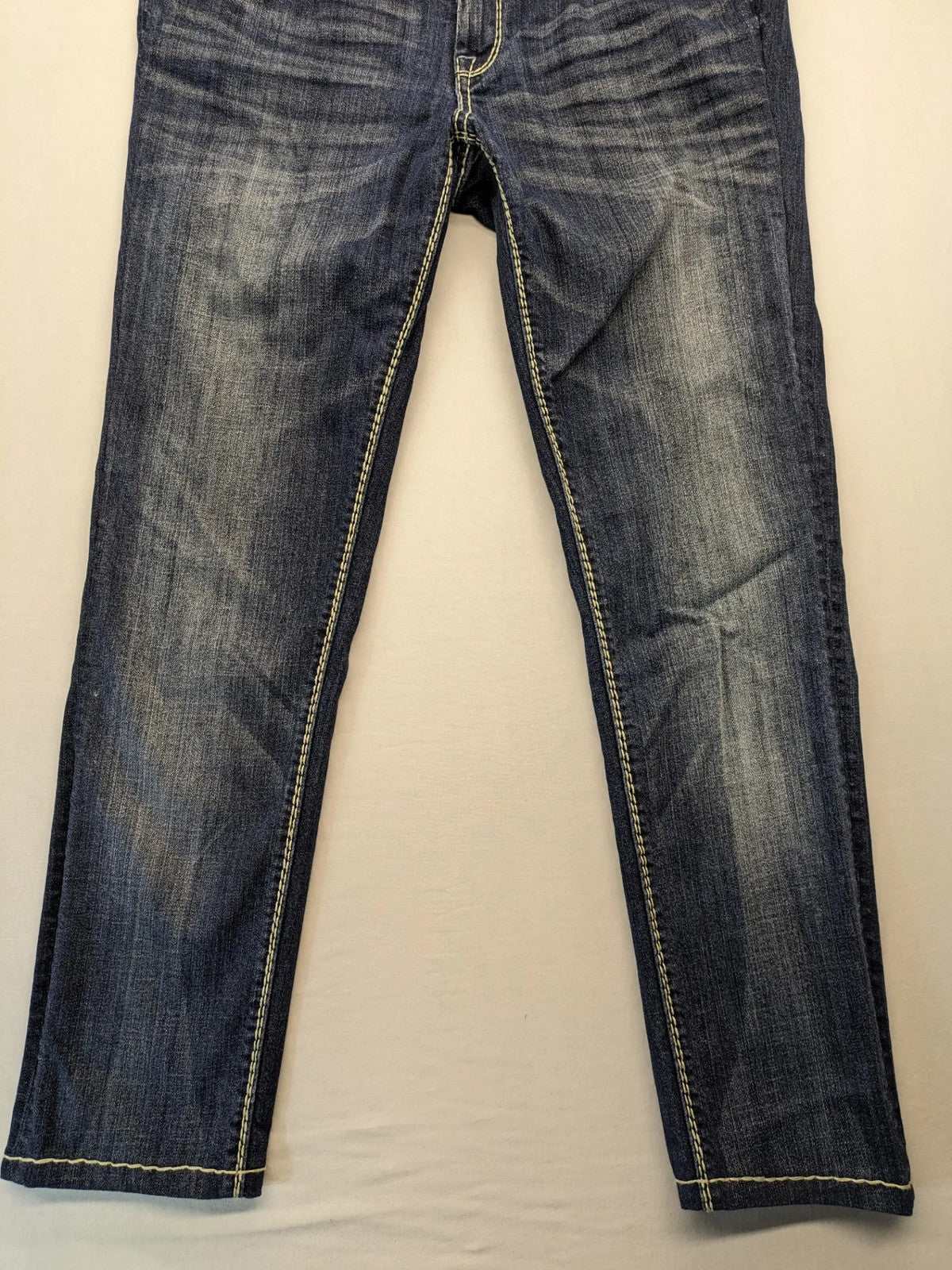 Rhodes blue skinny jeans with decorative studs and intricate embroidery on back pockets.