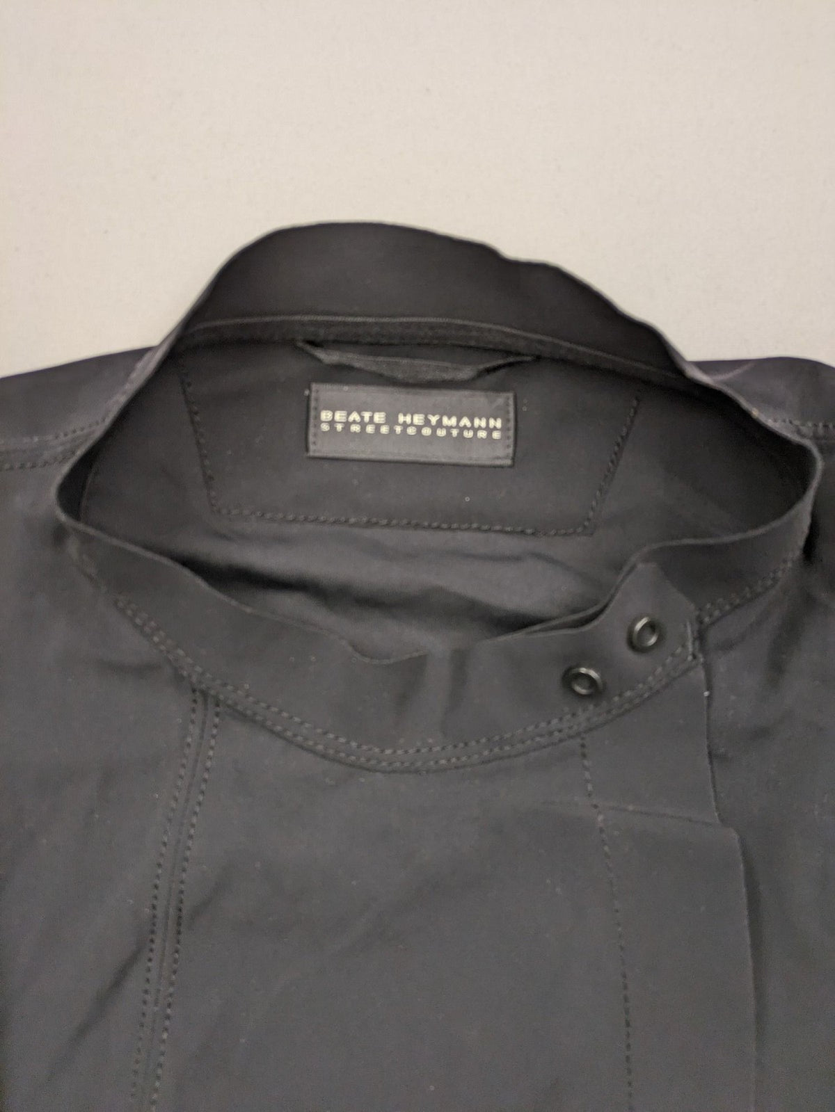 Beate Heymann black biker jacket with asymmetrical front and stand-up collar, stretch material.