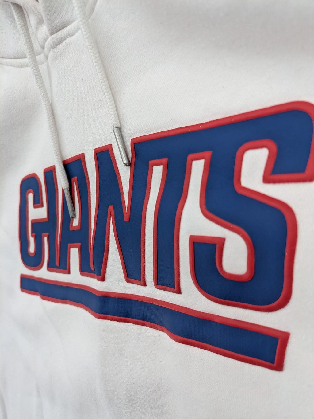 New York white hoodie with raised blue and red "GIANTS" logo and adjustable hood.