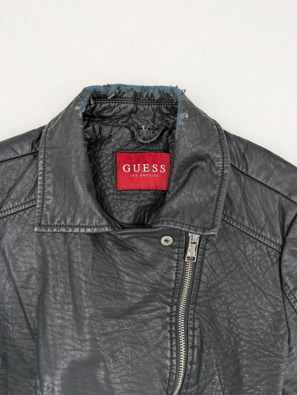Guess black faux leather biker jacket with asymmetric zipper and multiple zip pockets.