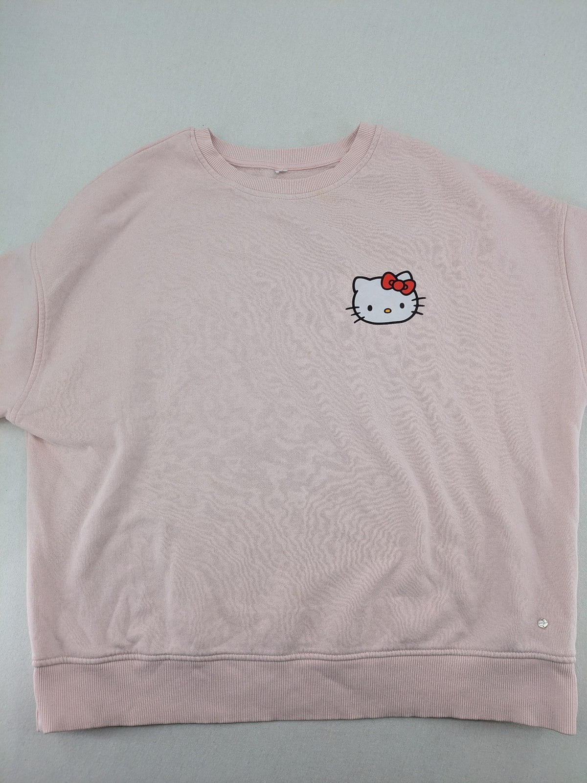Hello Kitty pink sweatshirt classic graphic face logo on chest, long sleeves, round neck.
