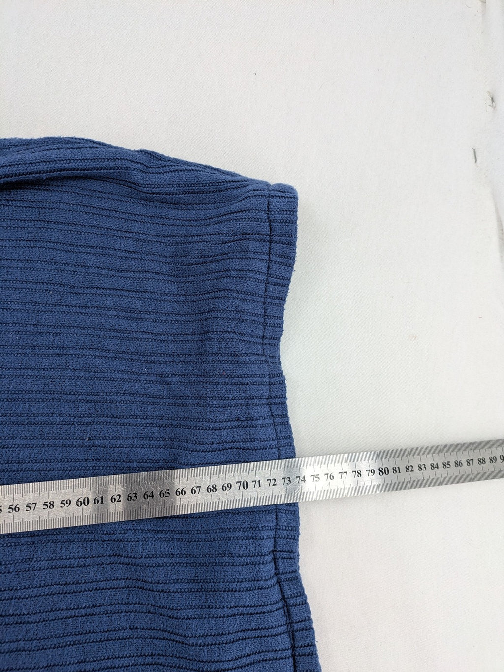 Secondhand blue tank top with ribbed texture and colorful decorative buttons.