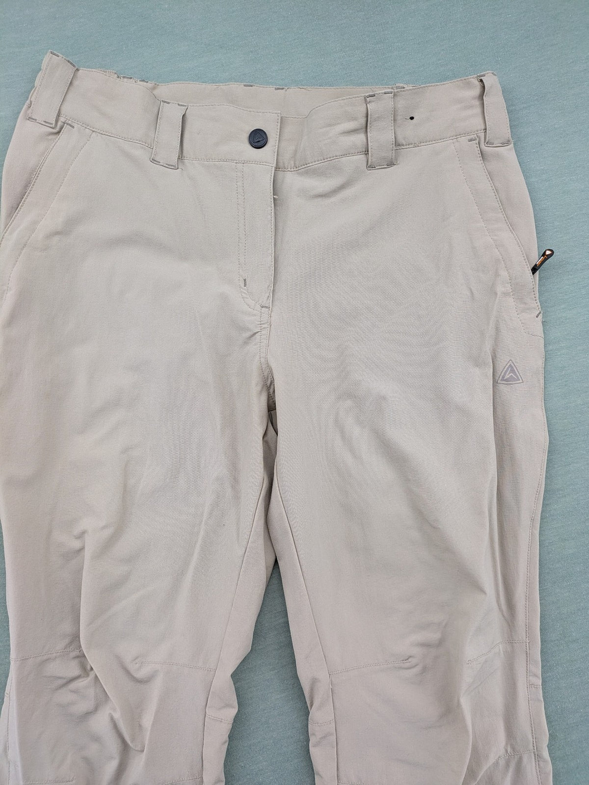 Hickory beige outdoor pants with multiple zippered pockets and stretch fabric for comfort.