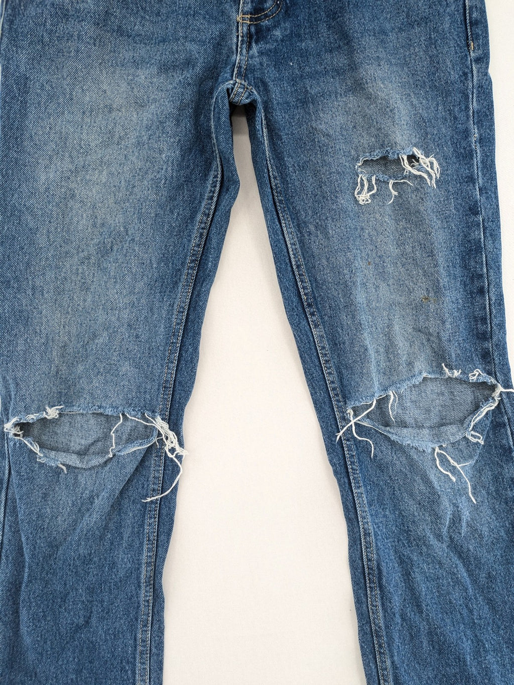 FSBN blue straight jeans with distressed knee rips and classic button fly.