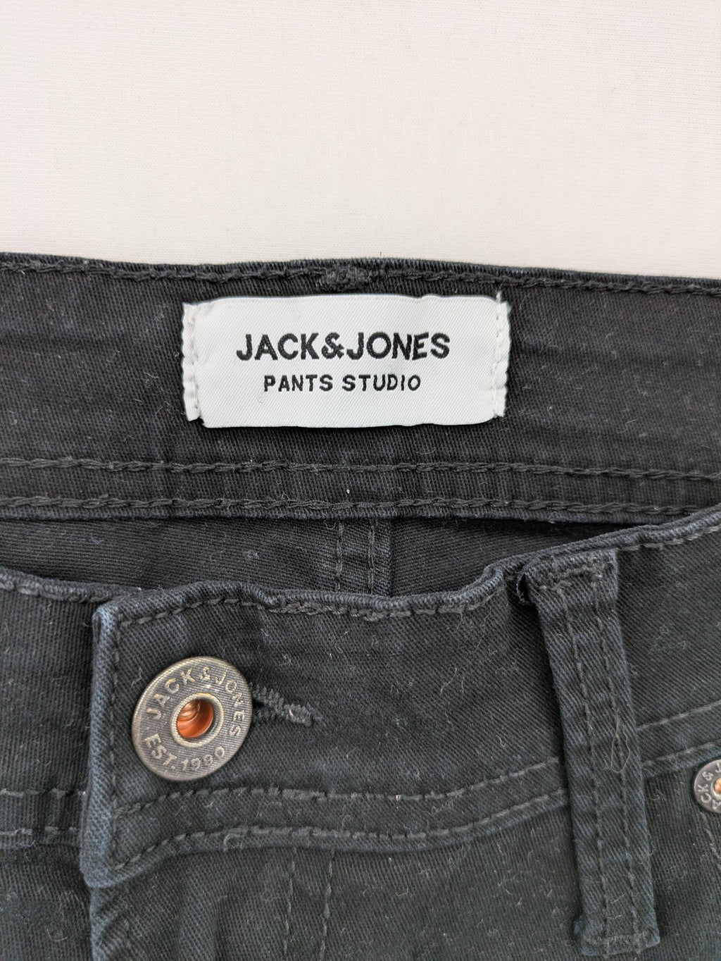 Jack & Jones black slim fit jeans with logo patch and cotton-stretch blend.