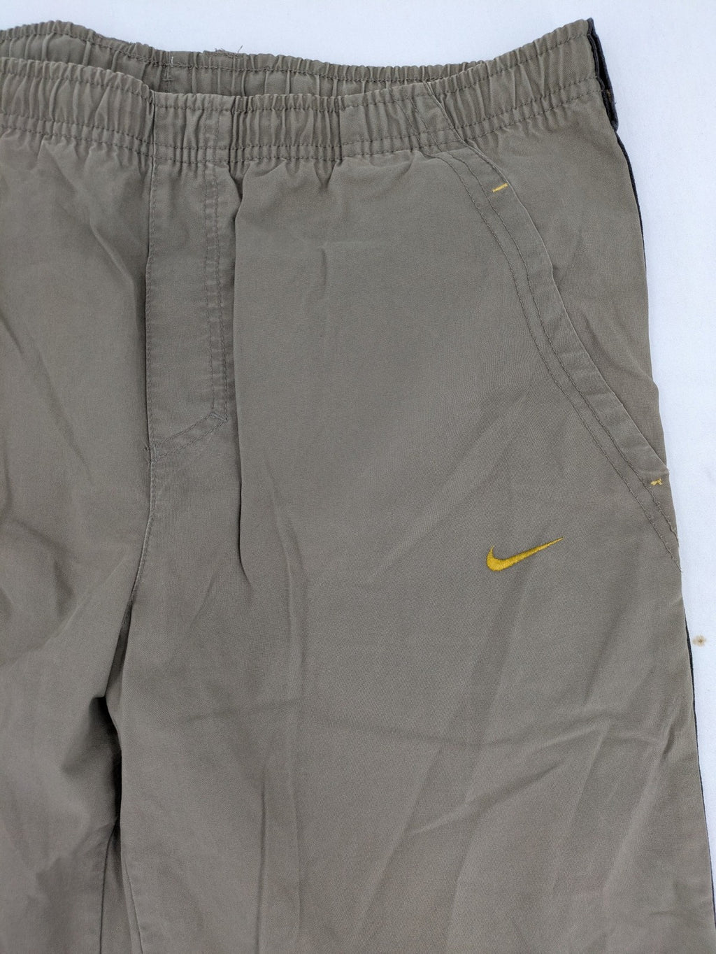 Nike khaki training pants with logo, elastic waistband, and practical pockets.