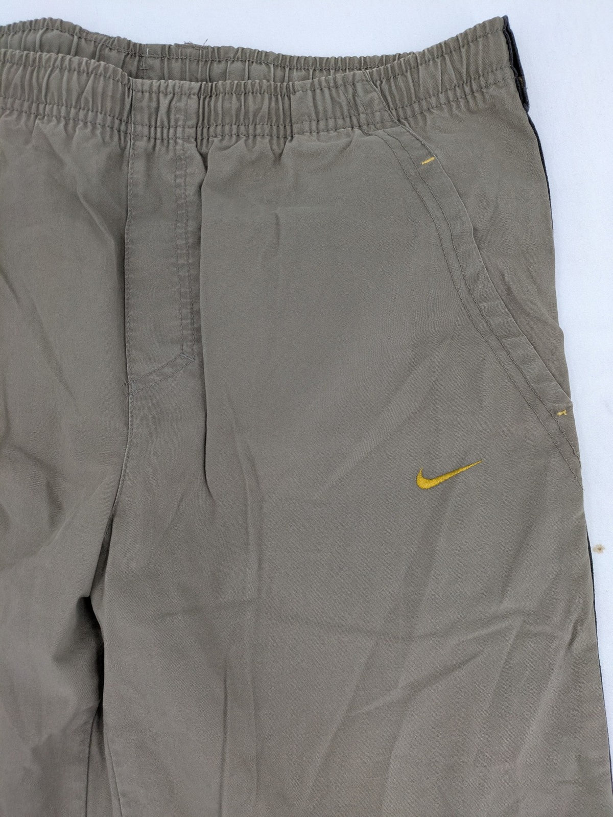 Nike khaki training pants with logo, elastic waistband, and practical pockets.