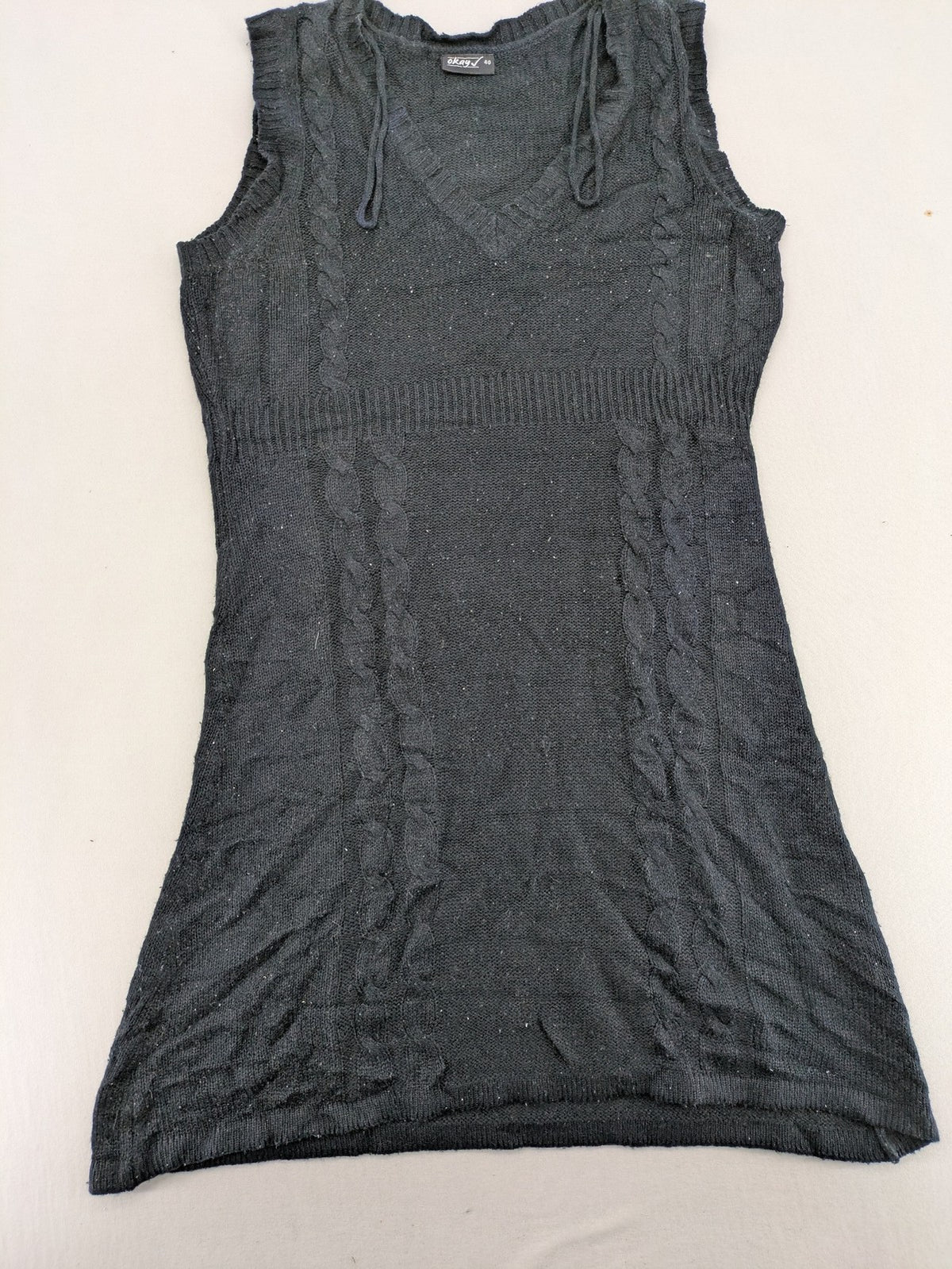 Okay black sleeveless dress V-neck with decorative cord and cable knit pattern.