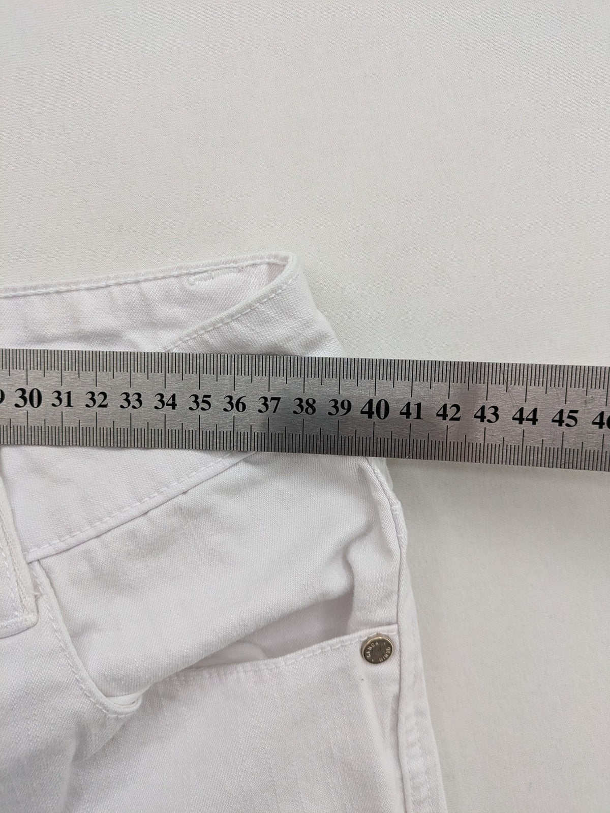 Canda white capri pants cotton-elastane blend with decorative zippers and stylish pockets.