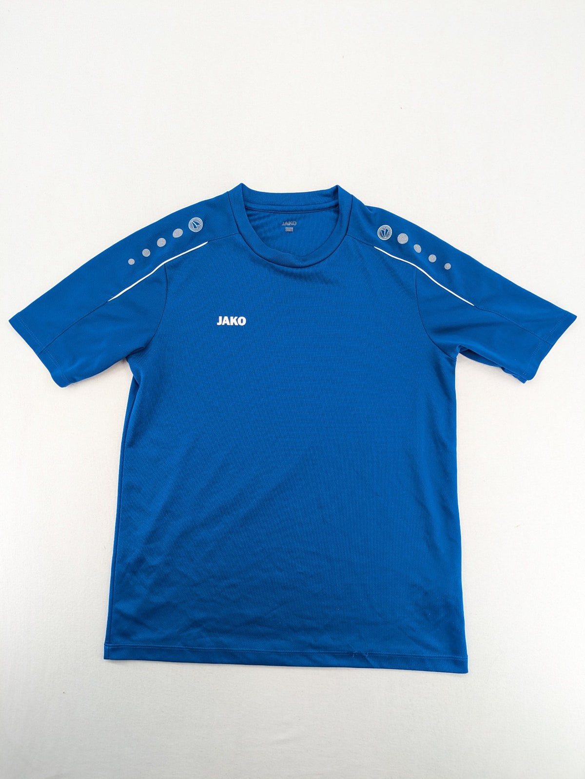 Jako blue short-sleeve training shirt with logo details and breathable polyester material.