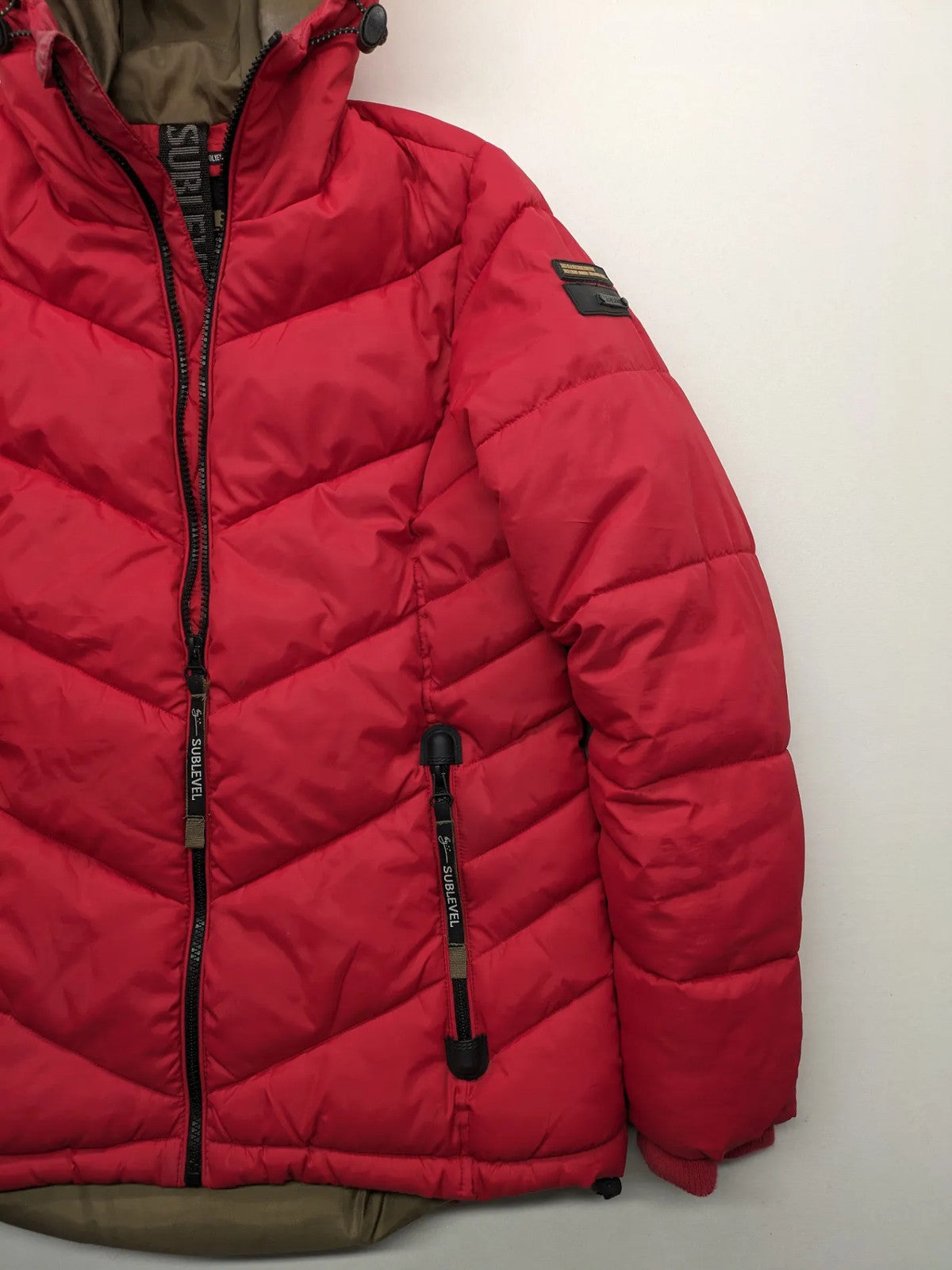 Sublevel red puffer jacket size S, chevron quilted pattern, adjustable hood, recycled polyester lining.