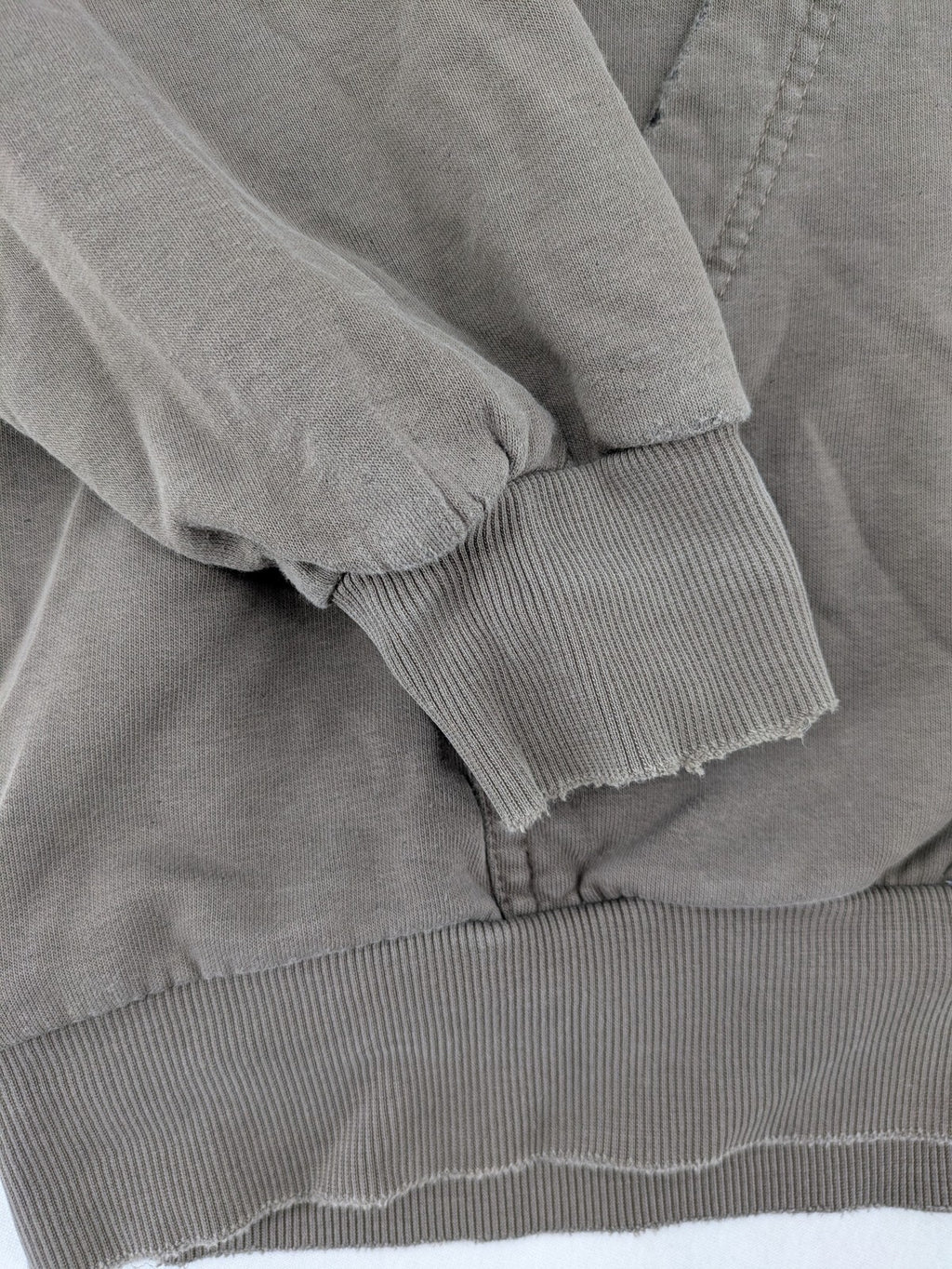 Mosquito grey hoodie with distressed cuffs and subtle logo on the chest.