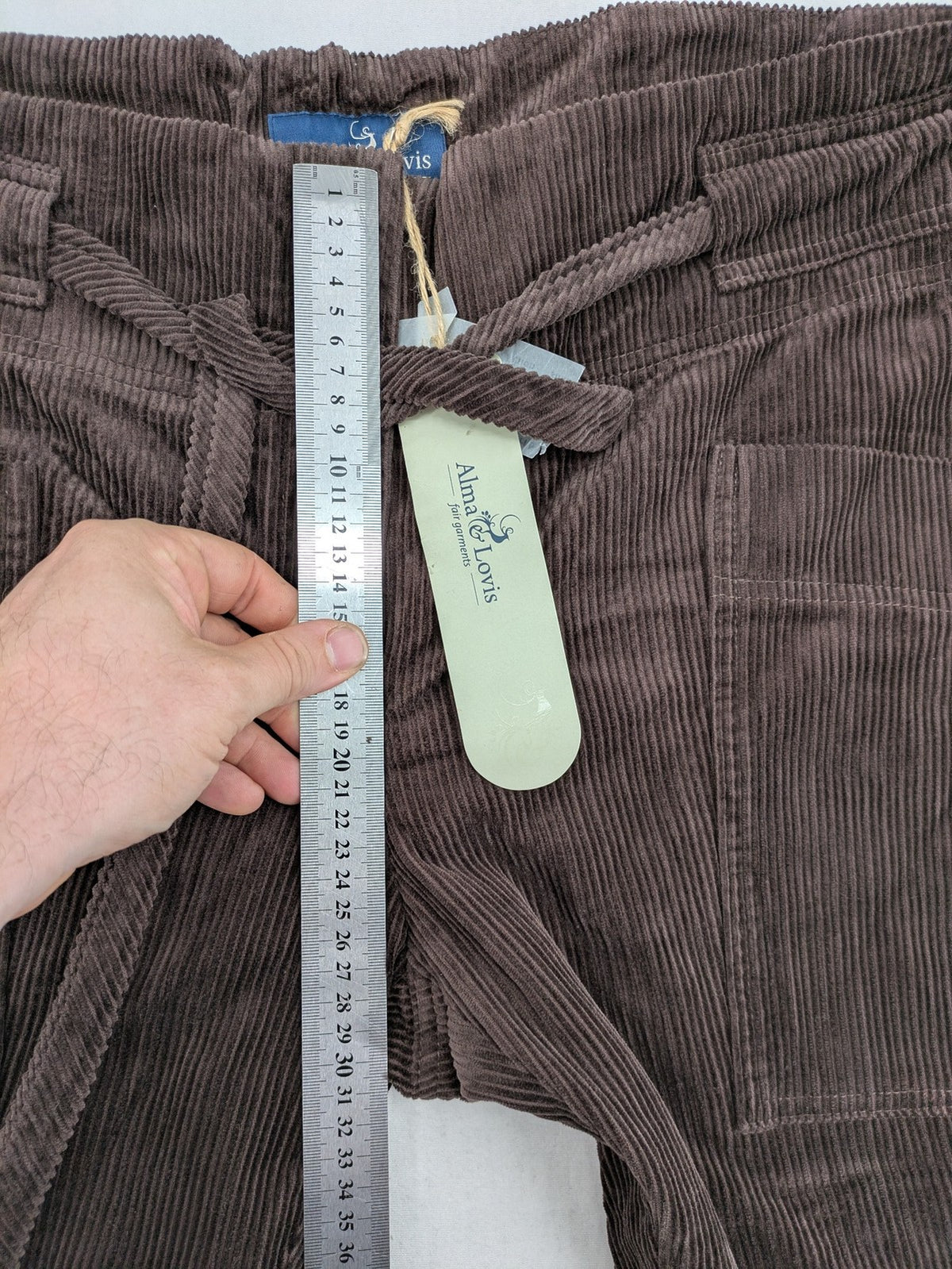 Alma & Lovis brown cord pants with elastic waistband, drawstring, and front patch pockets.