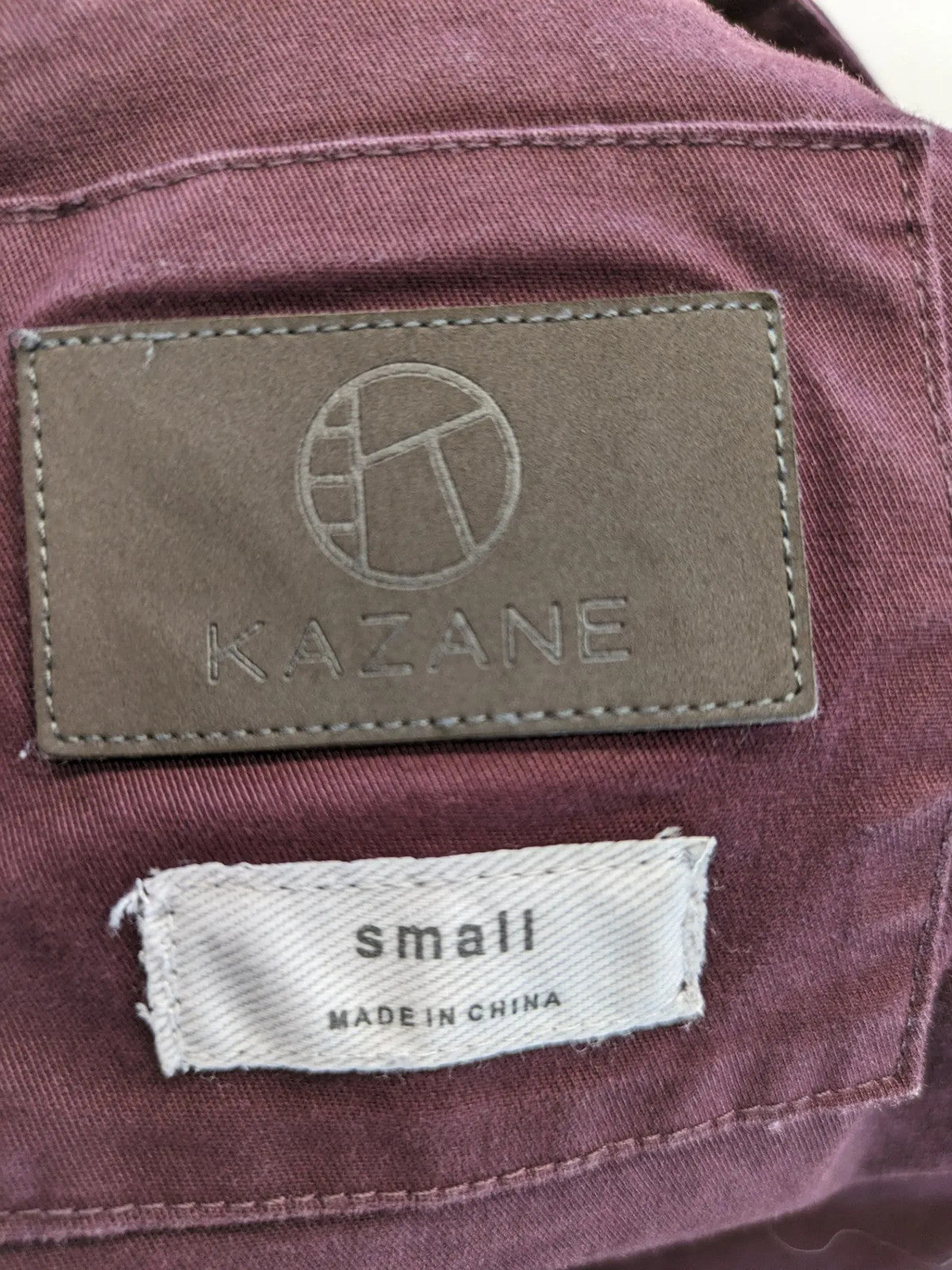 Kazane burgundy overalls with adjustable straps, side button placket, and chest pocket.