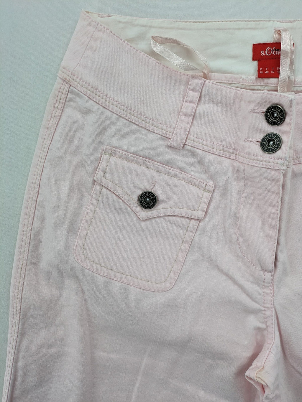 s.Oliver green bootcut pants with front pockets and button details, made of cotton-elastane blend.