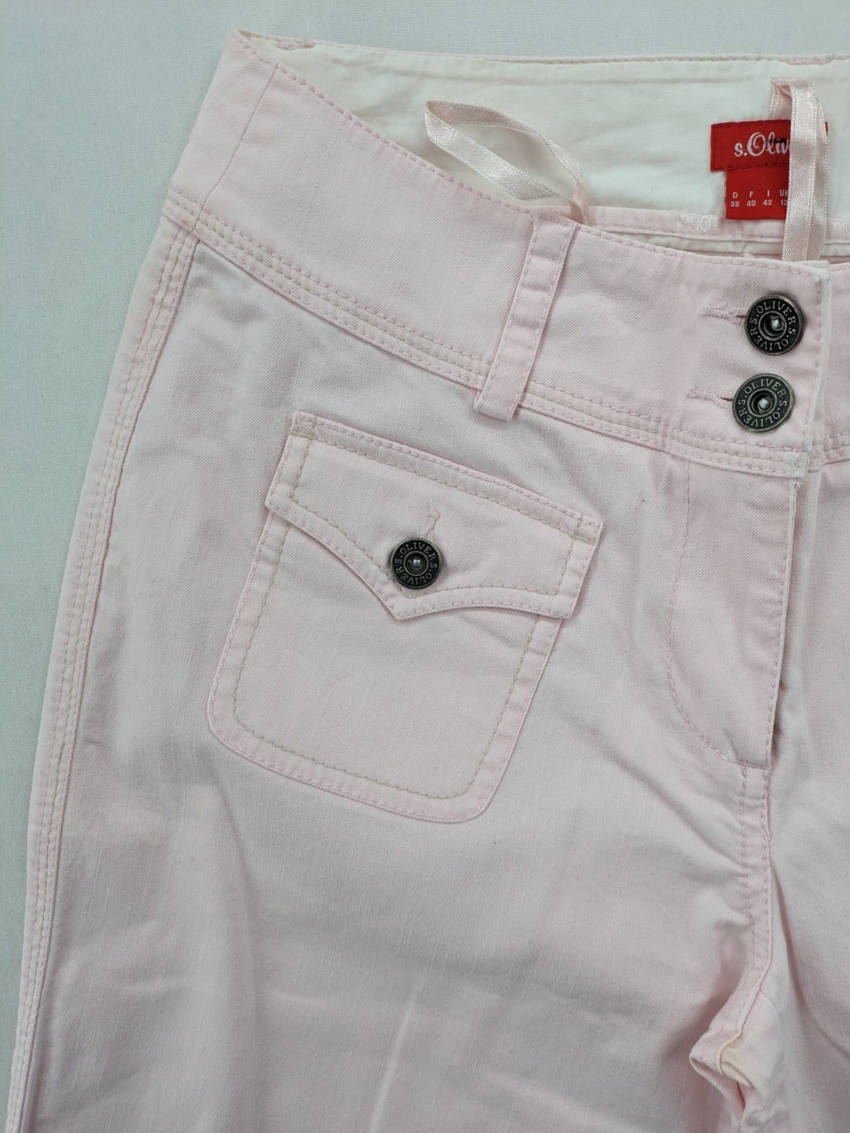 s.Oliver green bootcut pants with front pockets and button details, made of cotton-elastane blend.