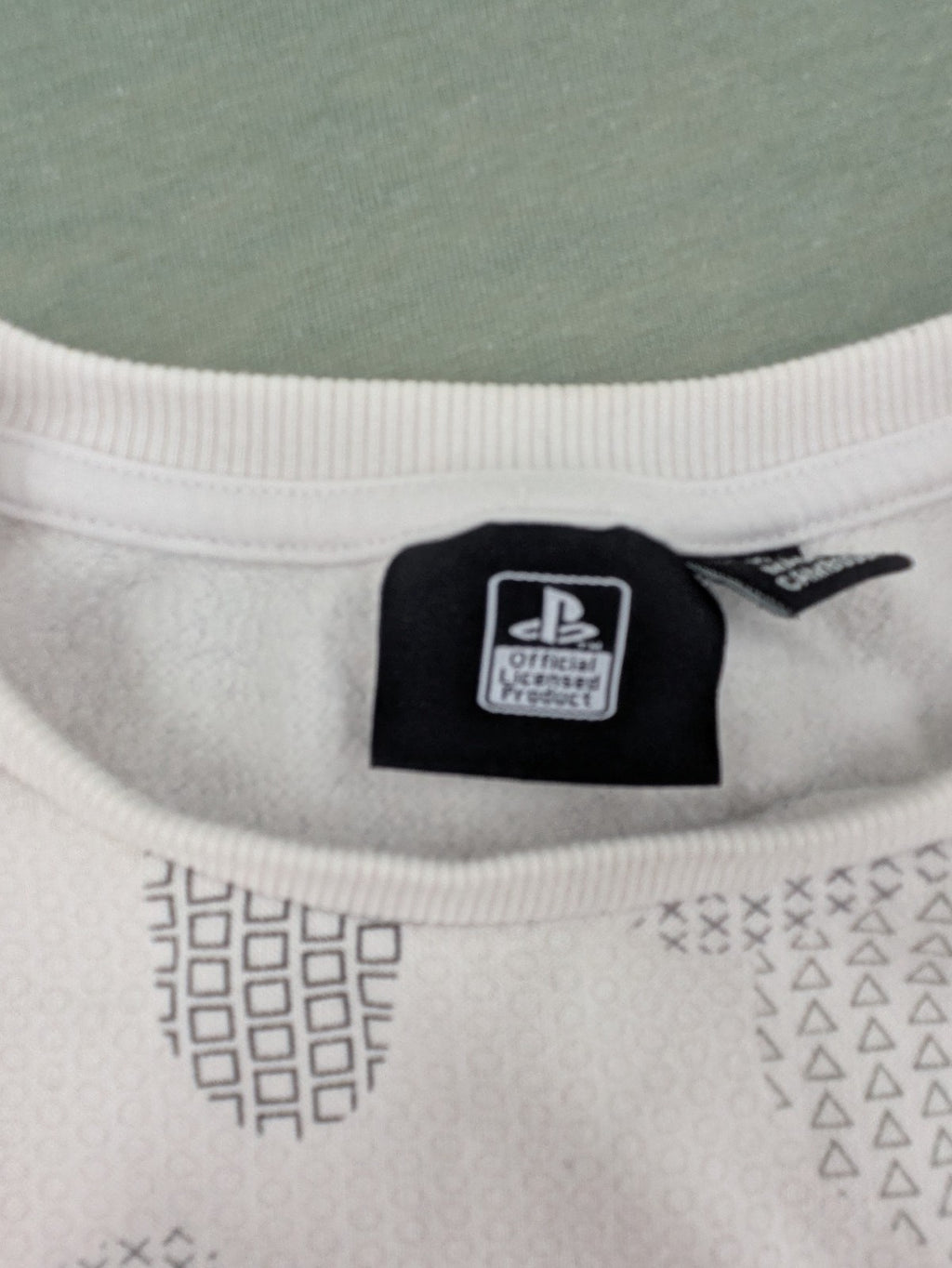 PlayStation grey sweatshirt with white logo and camo pattern featuring controller symbols.