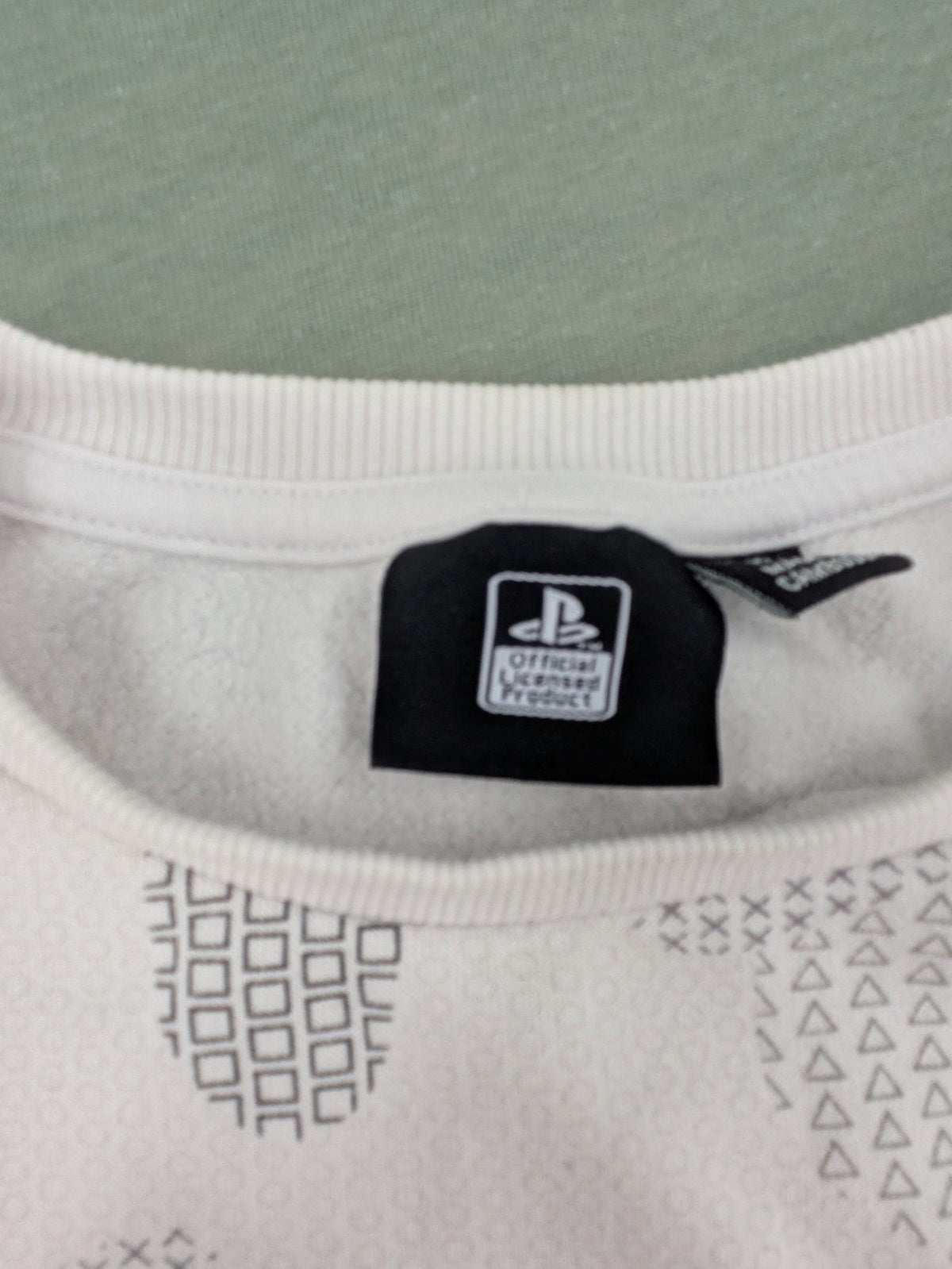 PlayStation grey sweatshirt with white logo and camo pattern featuring controller symbols.