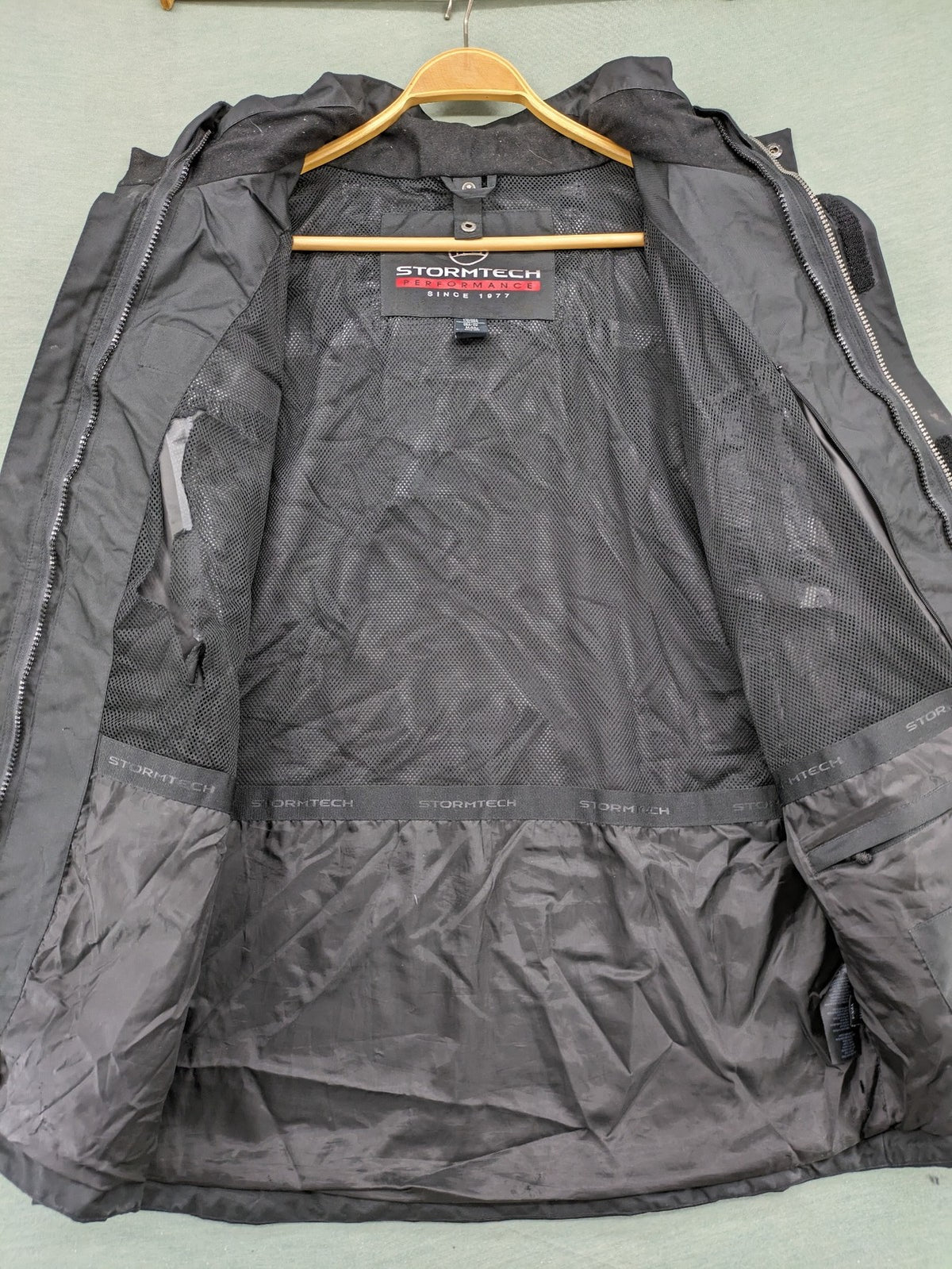 Stormtech black waterproof jacket with ZF logo, H2Xtreme technology, front zipper, and hood.