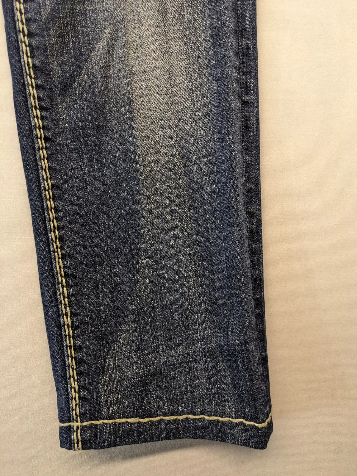 Rhodes blue skinny jeans with decorative studs and intricate embroidery on back pockets.
