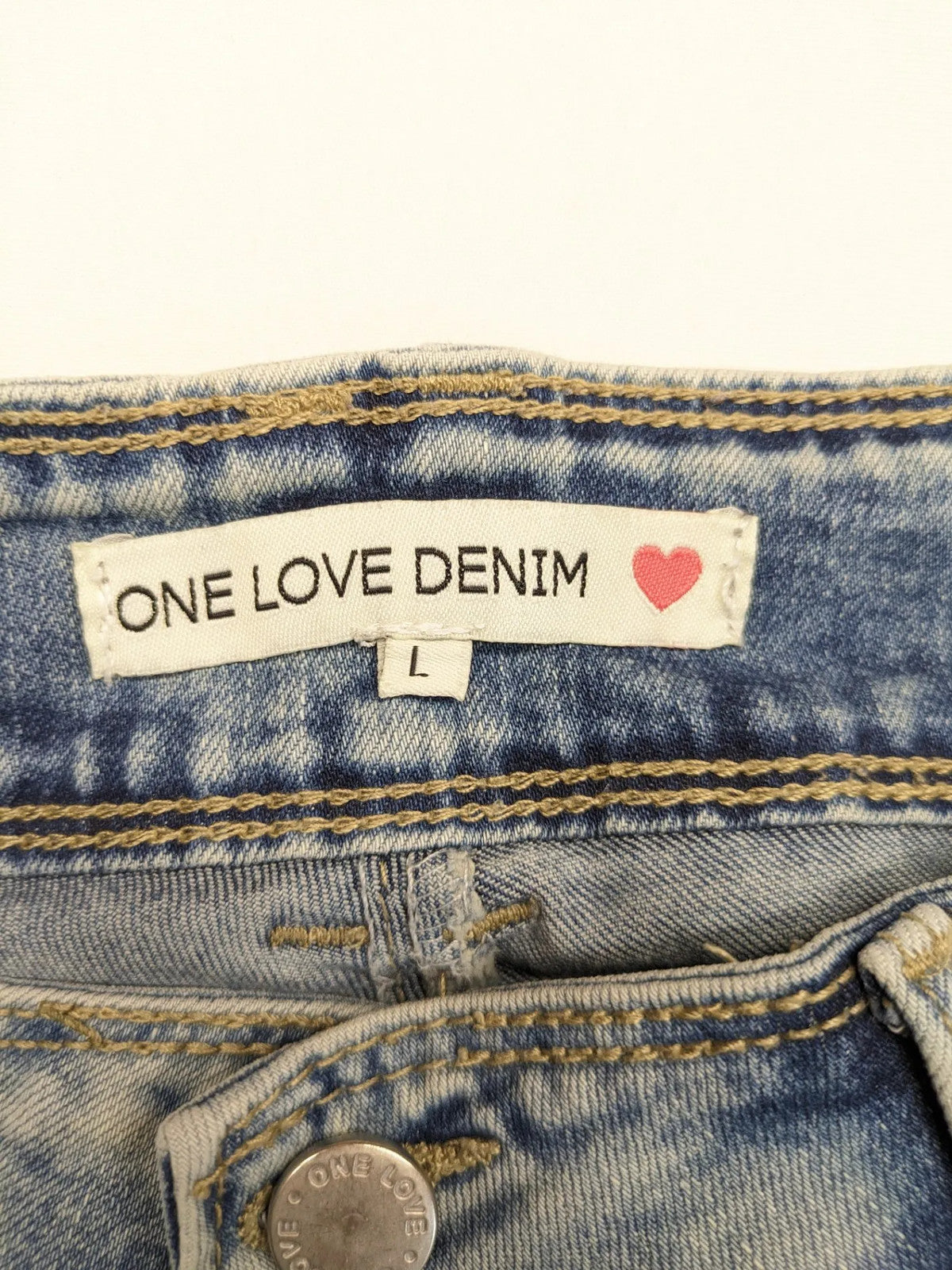ONE LOVE DENIM blue straight jeans with distressed details and double button closure.