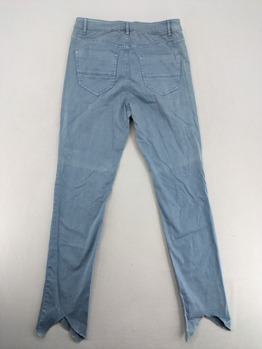Yessica blue skinny jeans high rise with button fly and V-cut hem detail.