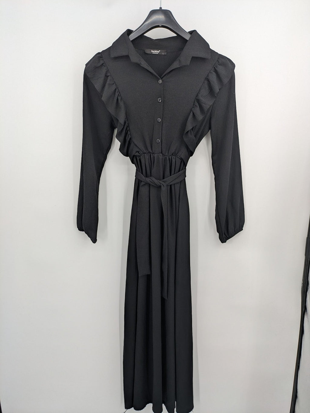 Hakke black maxi dress with ruffle details, long sleeves, and matching belt.