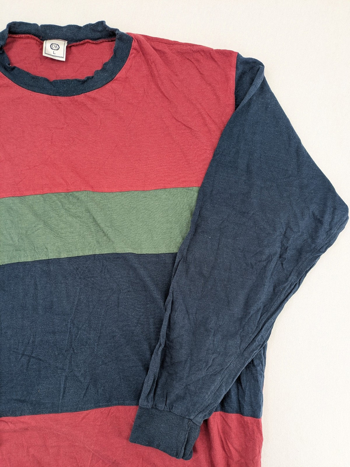 C&A green navy red colorblock long sleeve top with wide striped pattern and round neckline.