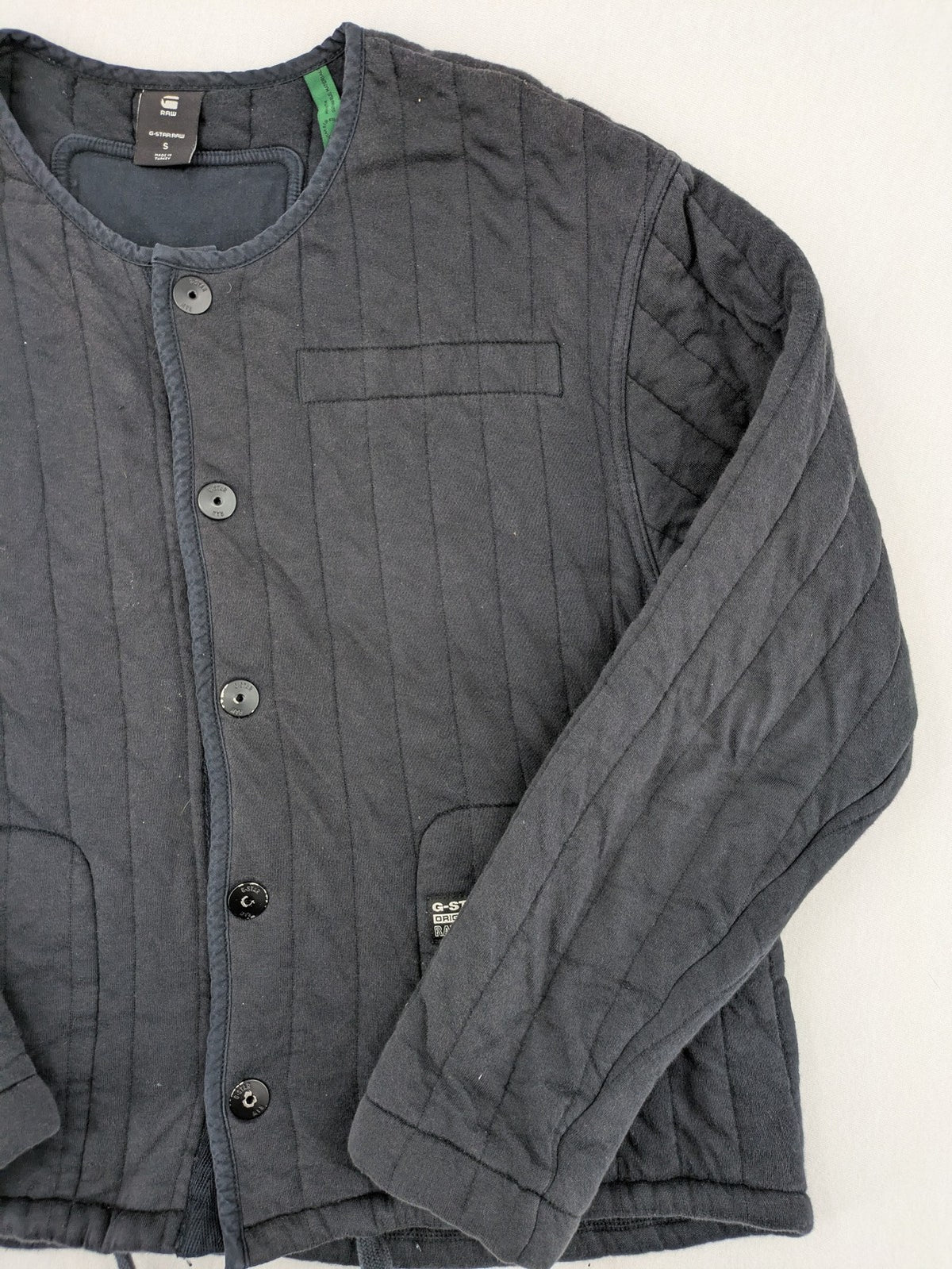 G-Star Raw grey quilted jacket with button closure and adjustable drawstring hem.