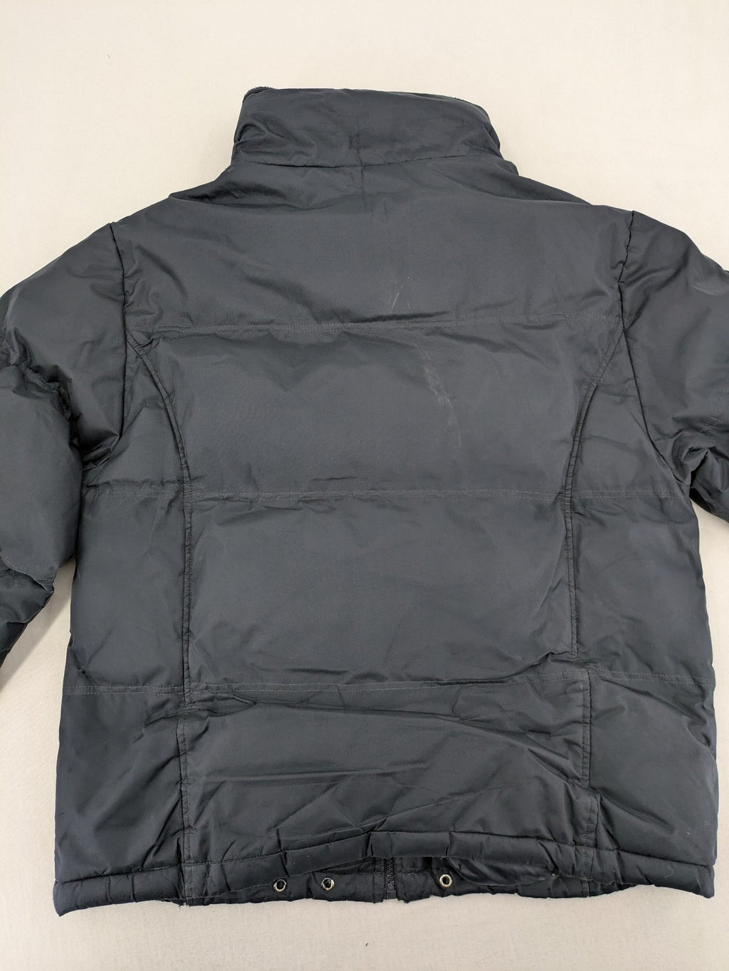 Identic black puffer jacket with quilted design and fleece-lined high collar.