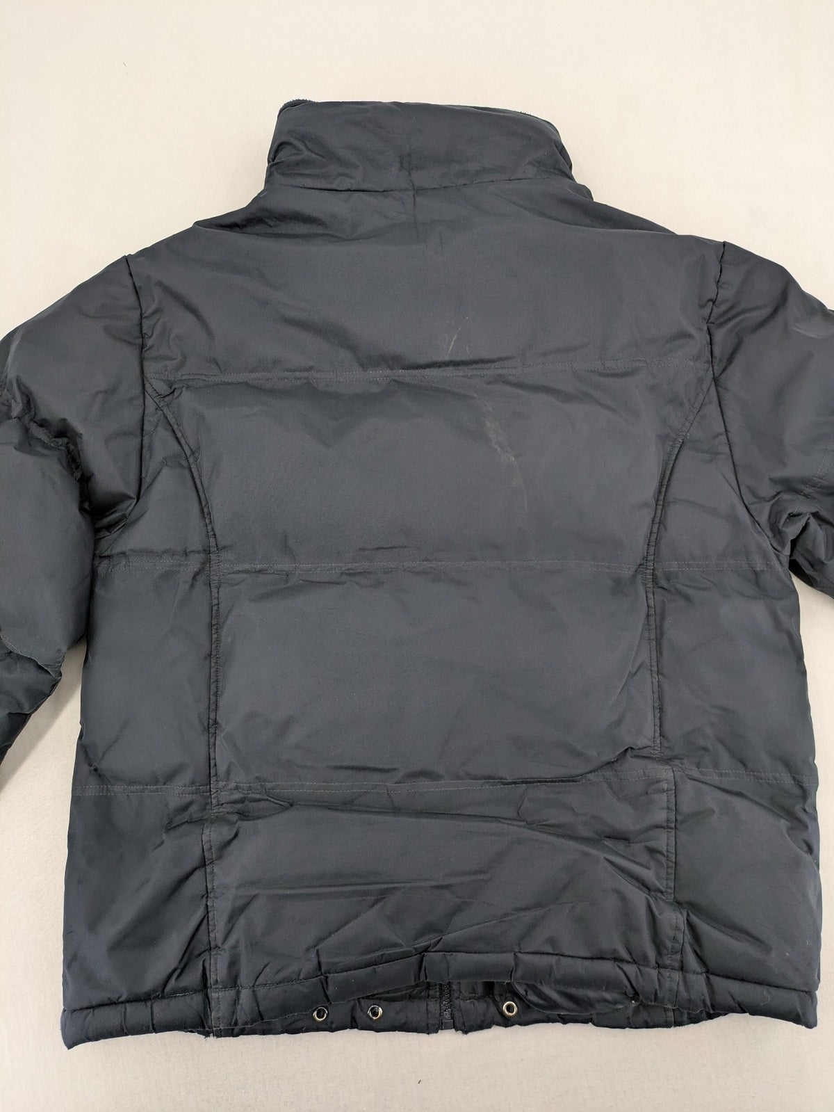 Identic black puffer jacket with quilted design and fleece-lined high collar.