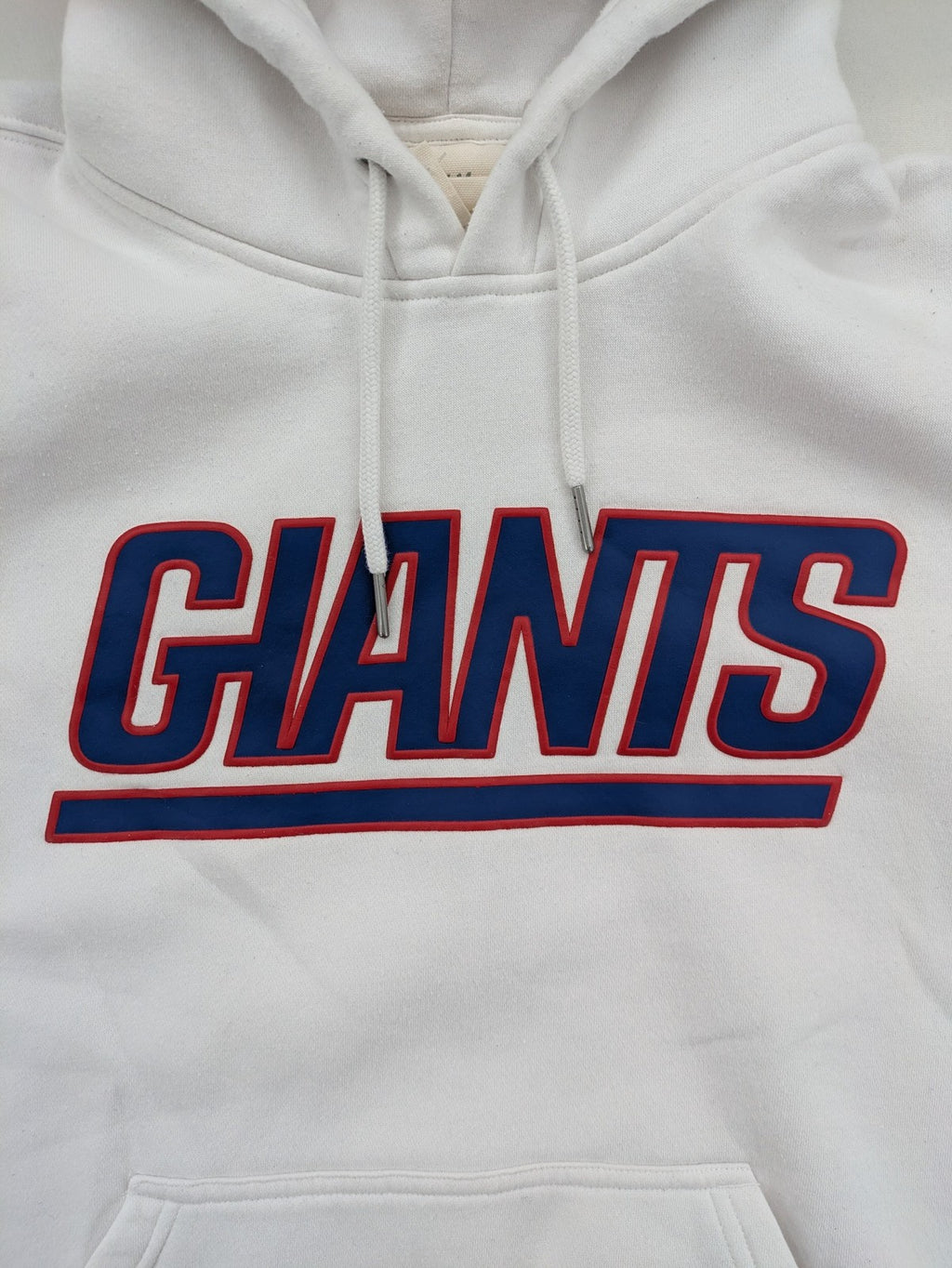 New York white hoodie with raised blue and red "GIANTS" logo and adjustable hood.