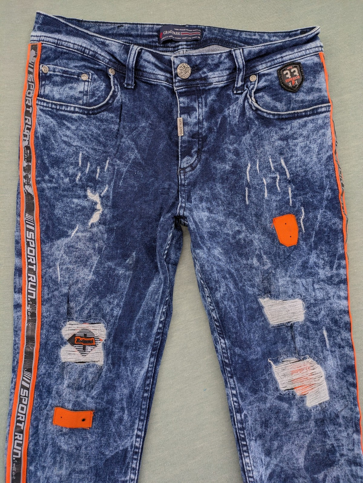 Stark straight jeans multi distressed acid wash with orange patches and side stripes.